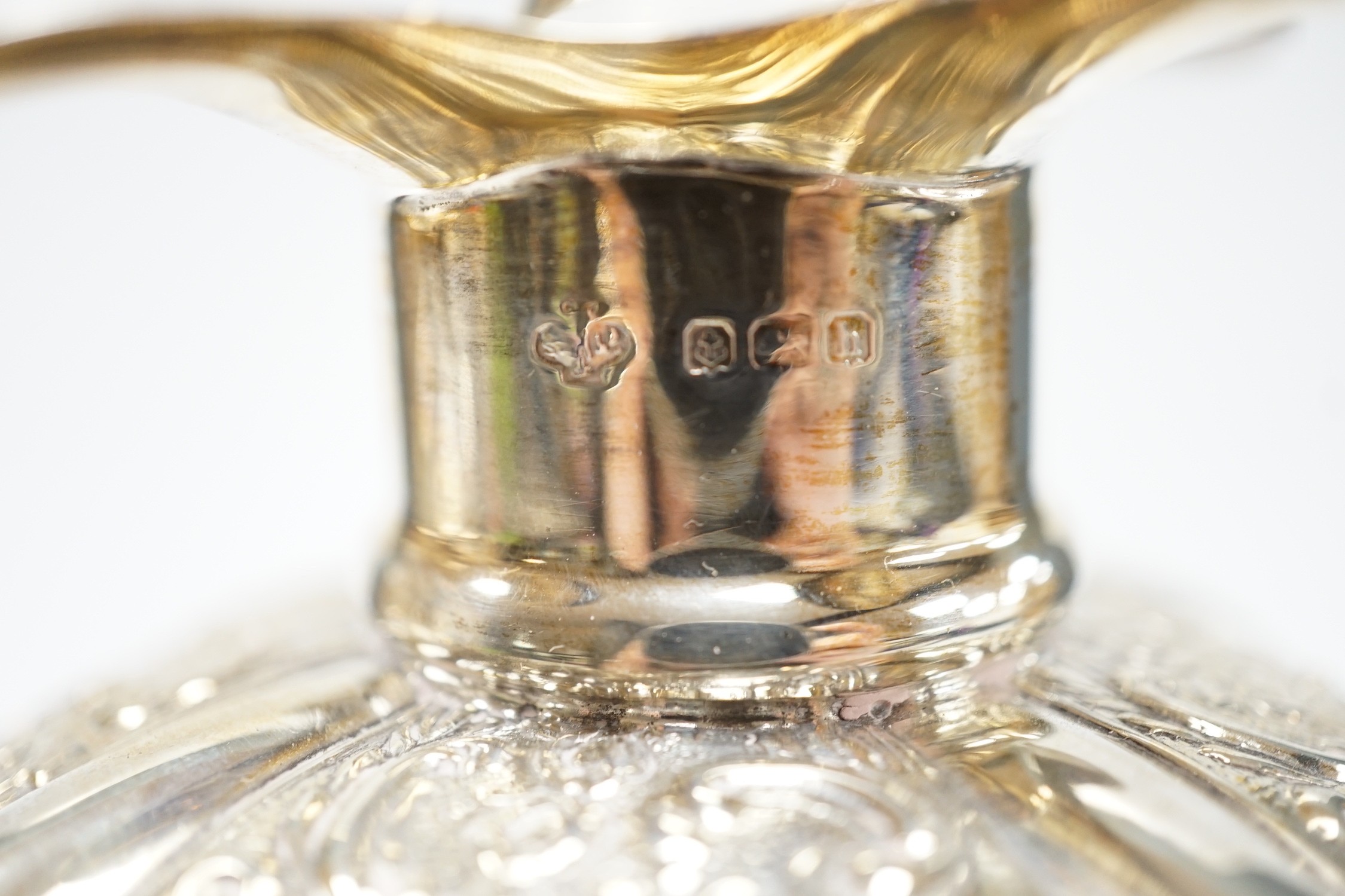 A pair of Edwardian silver mounted glass hour glass shaped decanters, William Hutton & Sons, Birmingham, 1906/7, with associated stoppers, height 23.9cm.